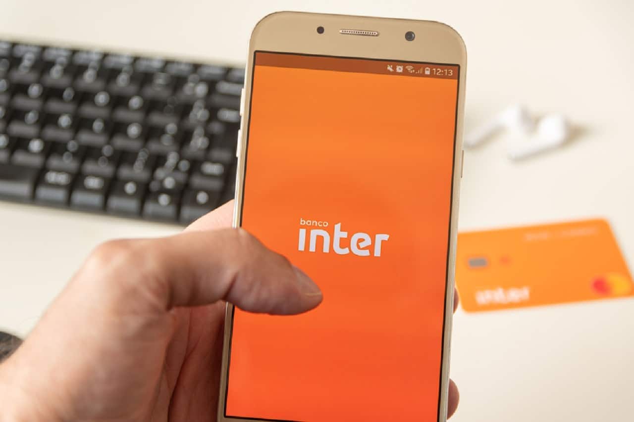 Imagem de uma pessoa mexendo no app do Banco Inter pelo celular