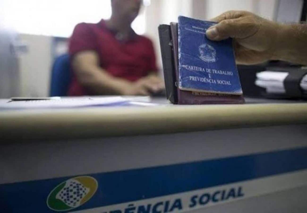 pessoa que recebe do inss com carteira de trabalho na mão