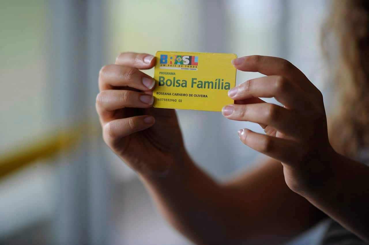 Imagem de uma pessoa segurando o cartão do Bolsa Família