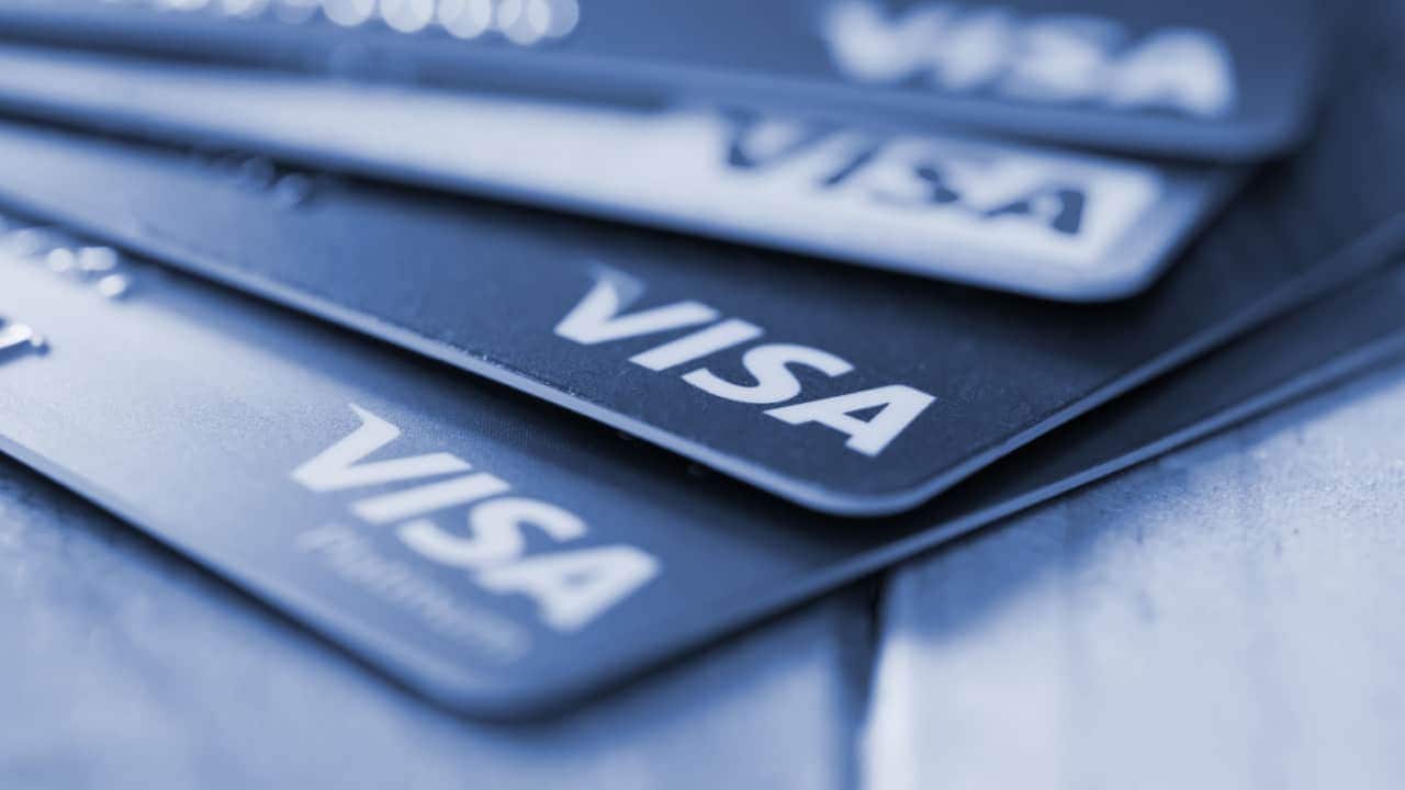 Quatro cartões Visa posicionados um sobre o outro, revelando o logo da marca em cada um
