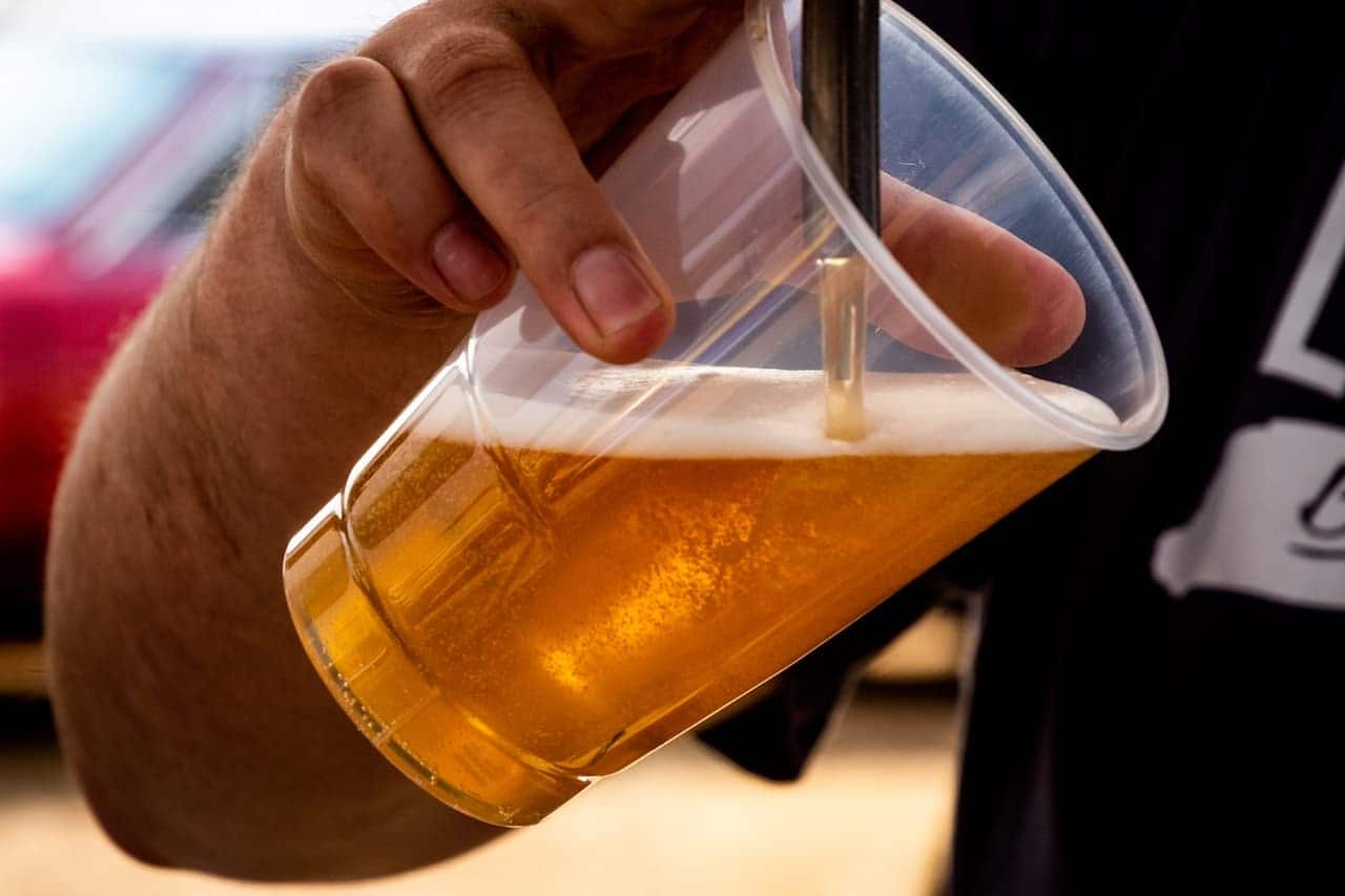Imagem de uma pessoa colocando cerveja em um copo.