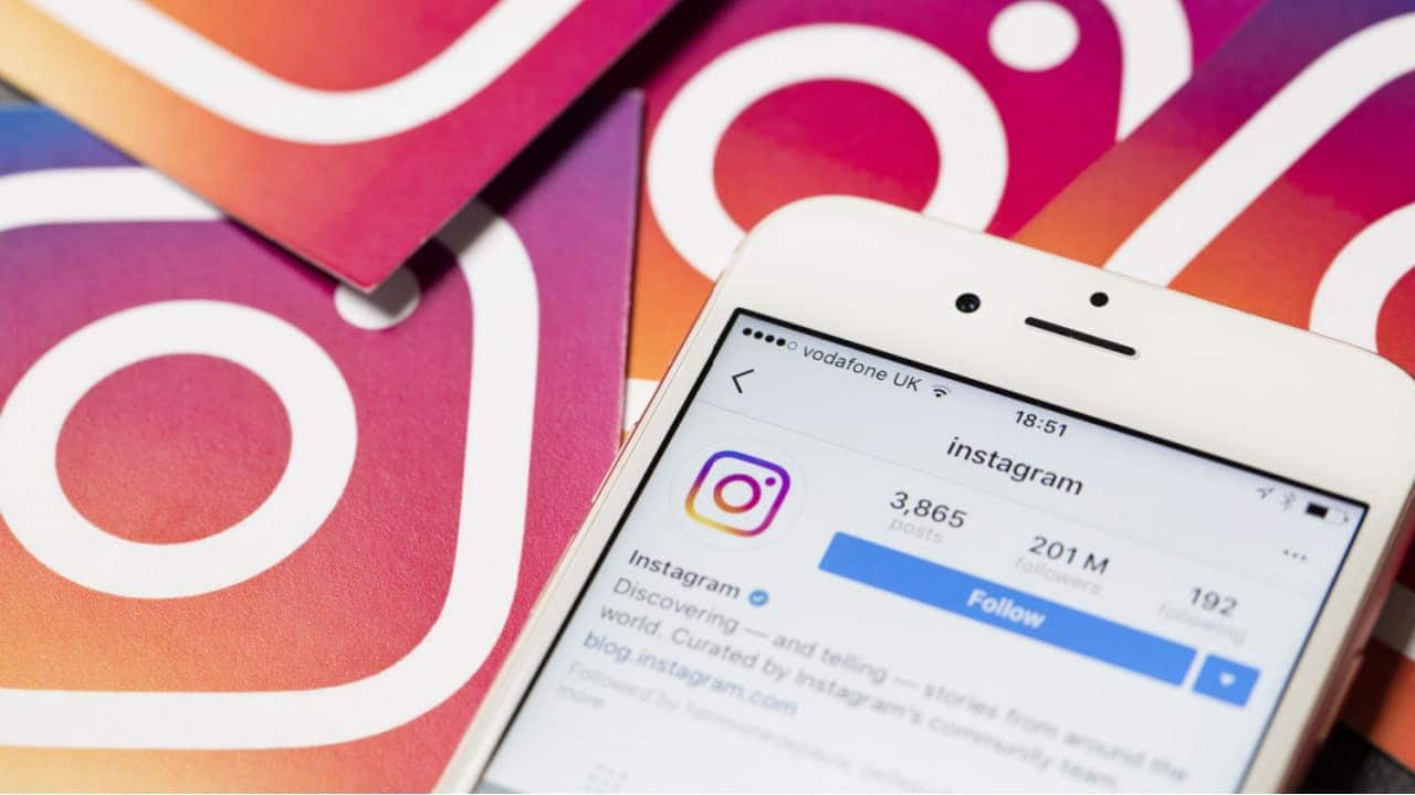 Celular mostrando conta oficial do Instagram na plataforma. Ao lado, vários logotipos da rede social.