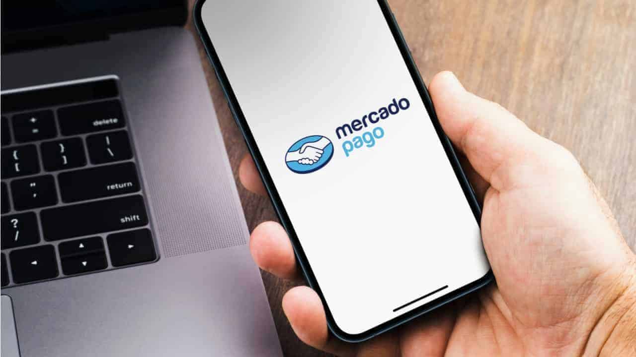 Pessoa segurando celular com o aplicativo do Mercado Pago