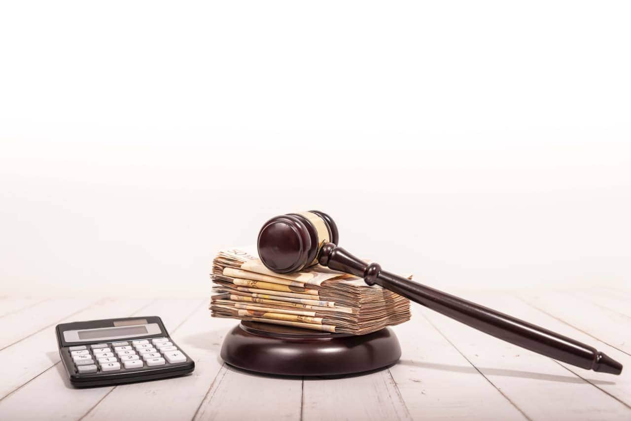 Calculadora, notas de dinheiro e martelo da justiça