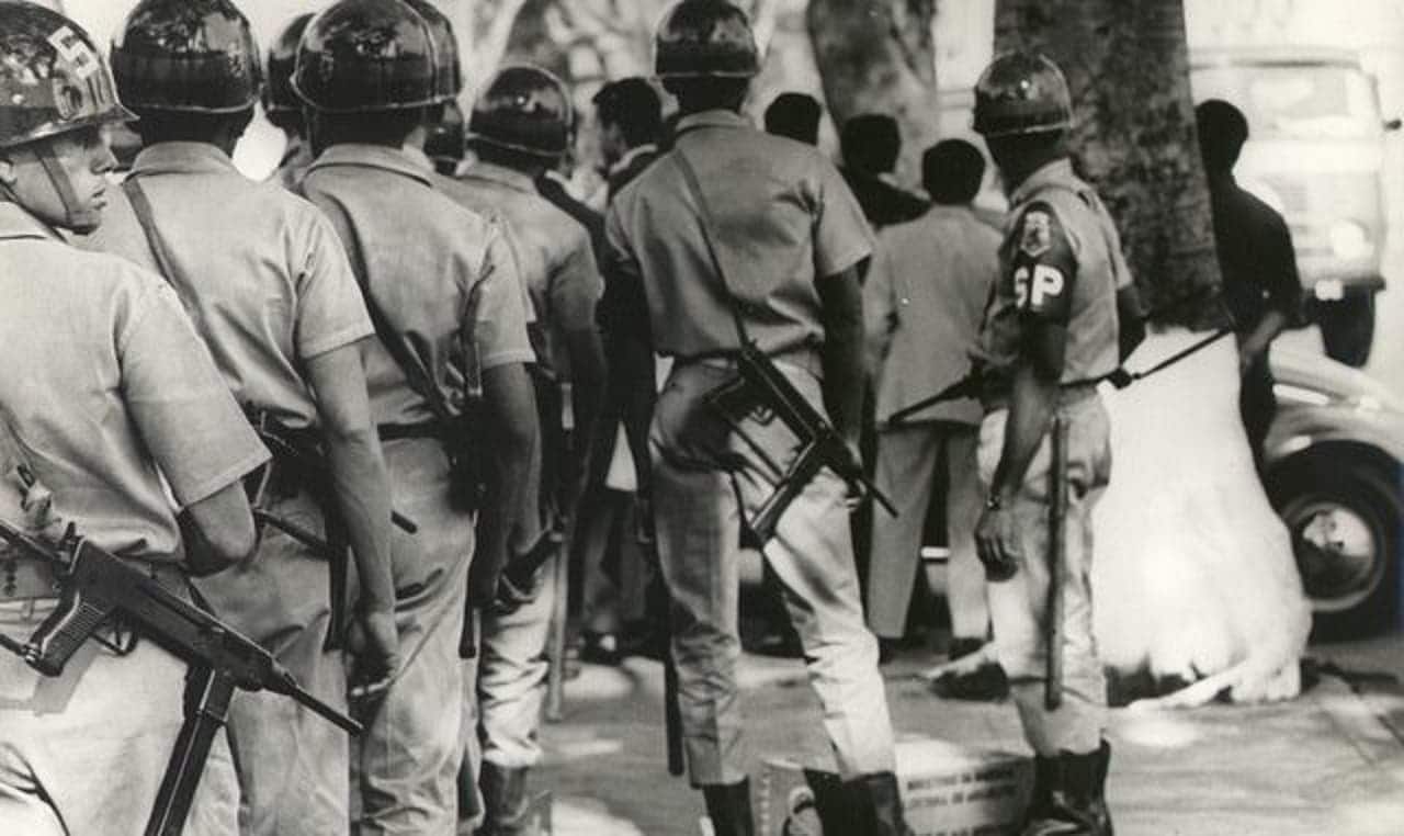 imagem antiga de militares armados em manifestação contra a ditatura militar nos anos 70