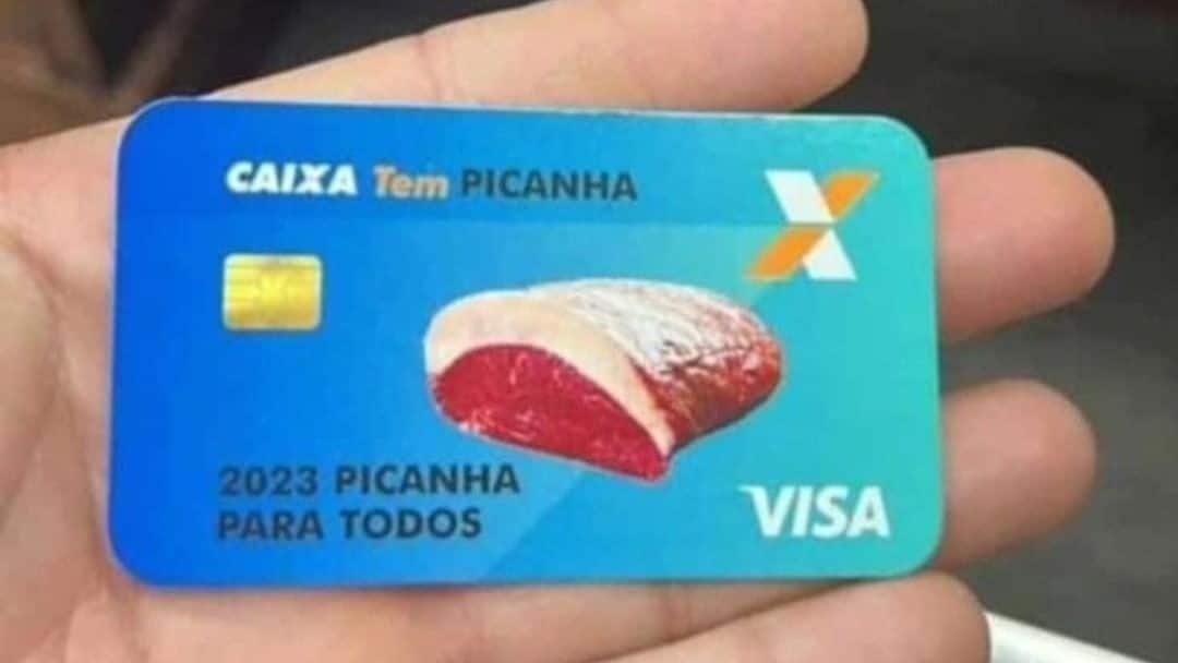 Mão de uma pessoa segurando falso cartão do Bolsa Picanha, com uma imagem da carne, do logo da Caixa e a frase "Picanha para todos"