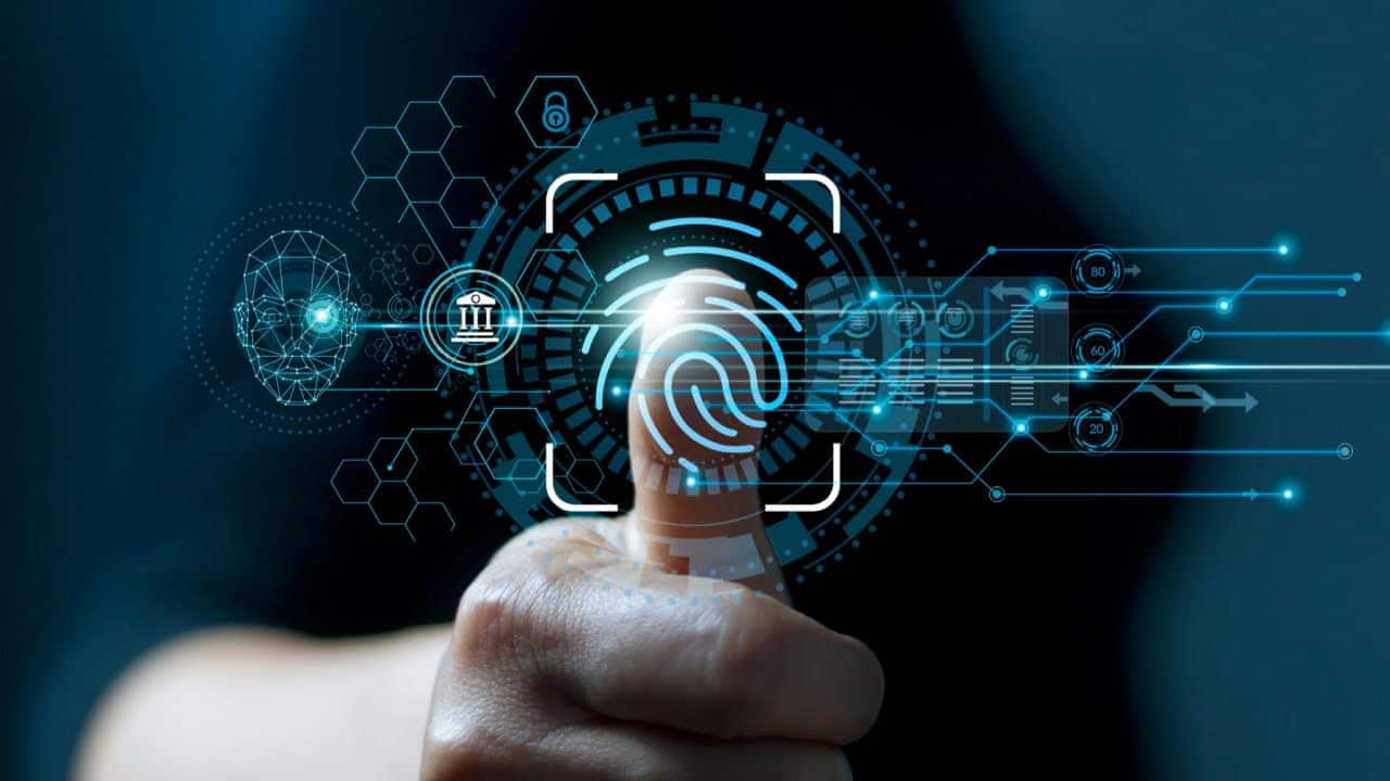 Mão de uma pessoa com polegar levantado sobre desenhos digitais de verificação de identidade