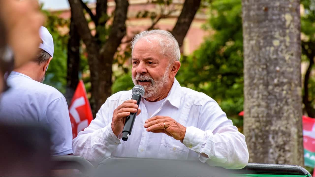 Presidente Lula discursando com um microfone em ambiente aberto