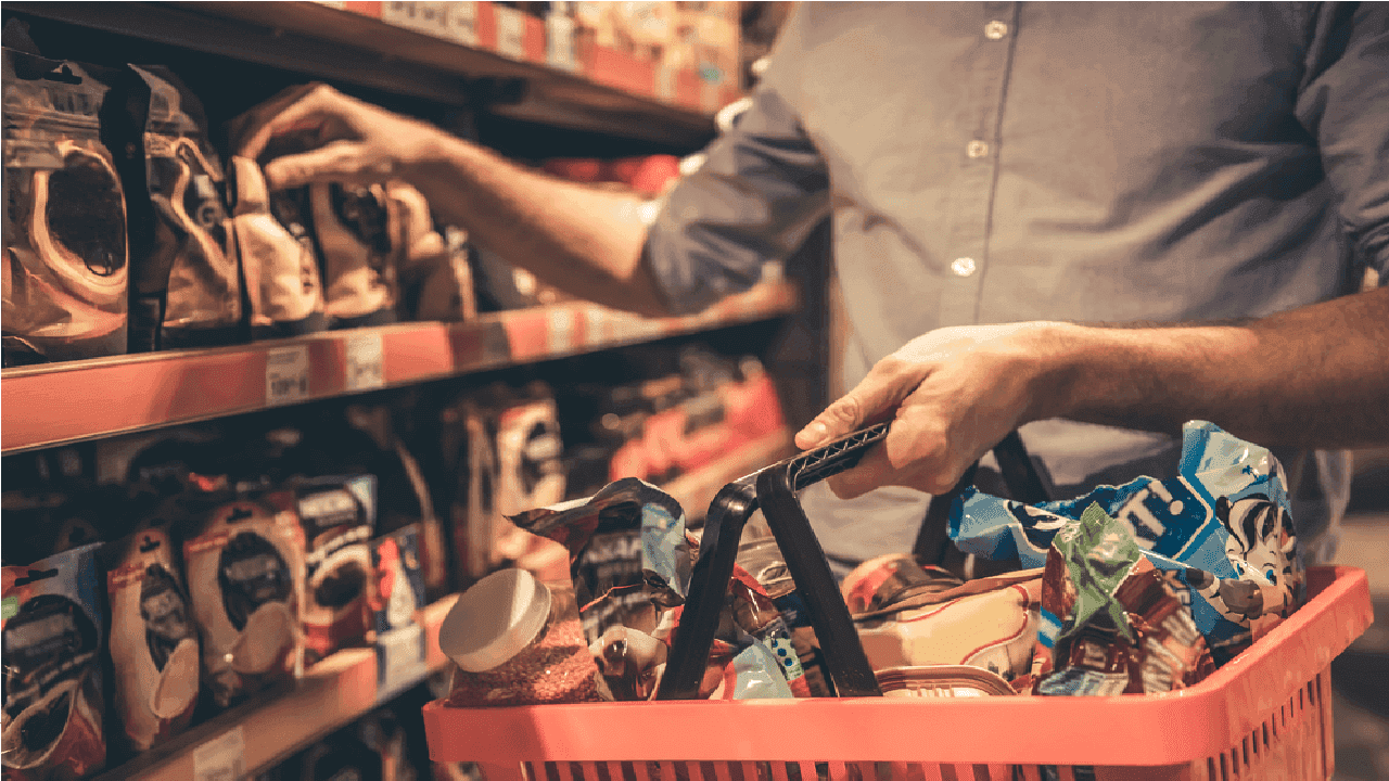 Imagem de pessoa pegando um produto dentro de um supermercado para compra