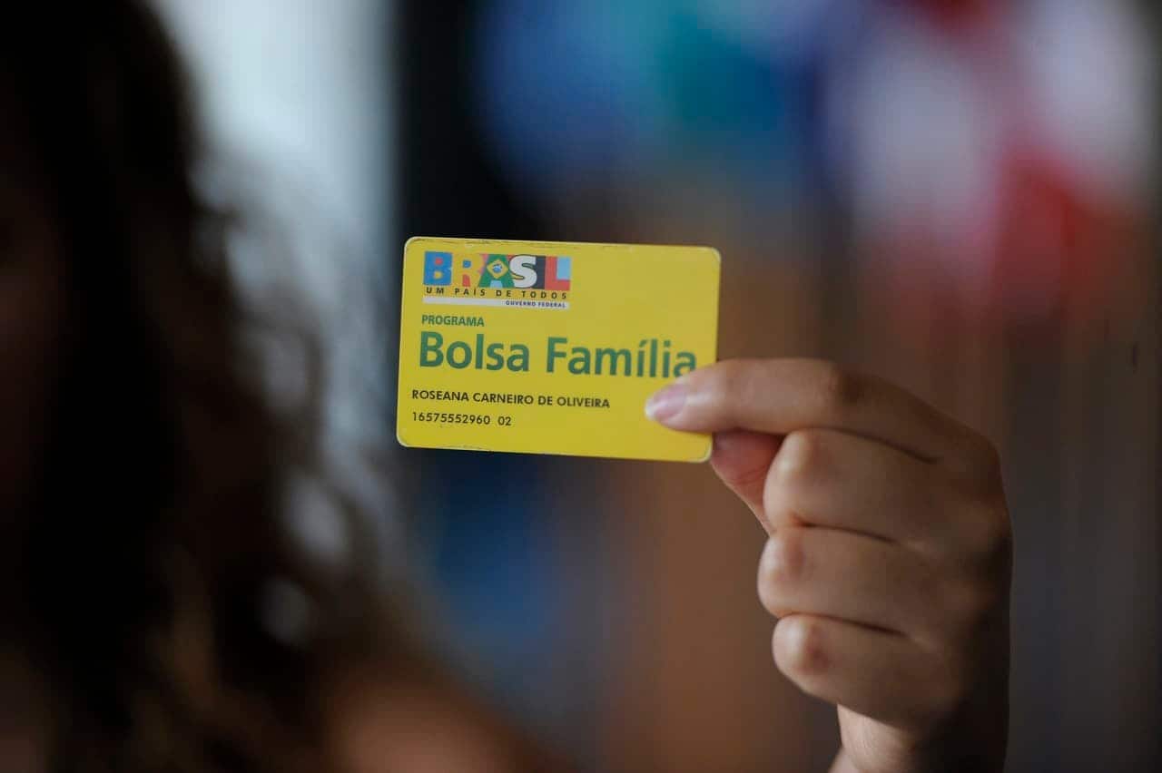 Imagem de uma pessoa segurando o cartão do Bolsa Família