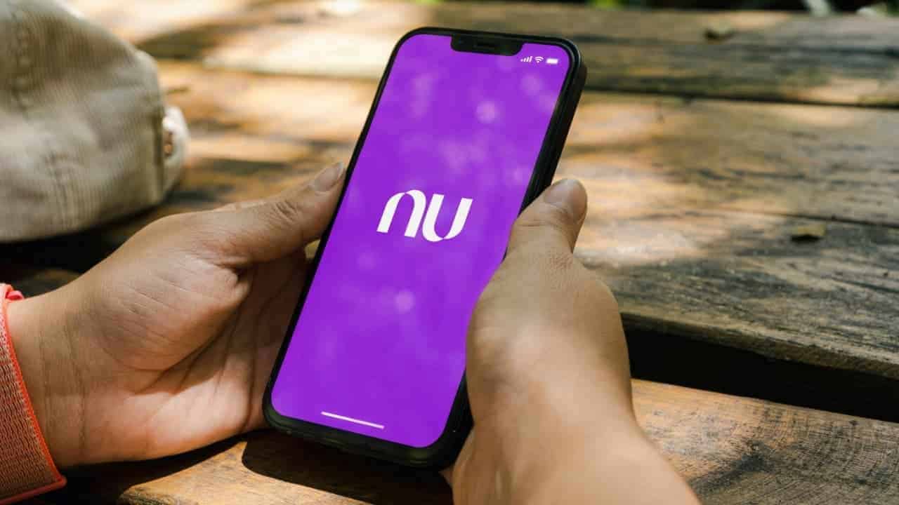 Mãos utilizando celular, com tela exibindo o aplicativo do Nubank
