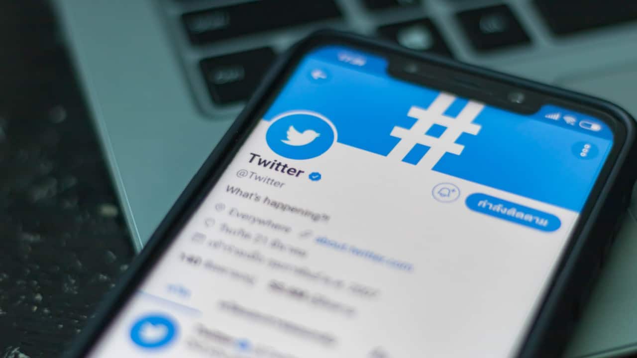 Celular sobre teclado de computador mostra perfil oficial do Twitter no aplicativo da rede social