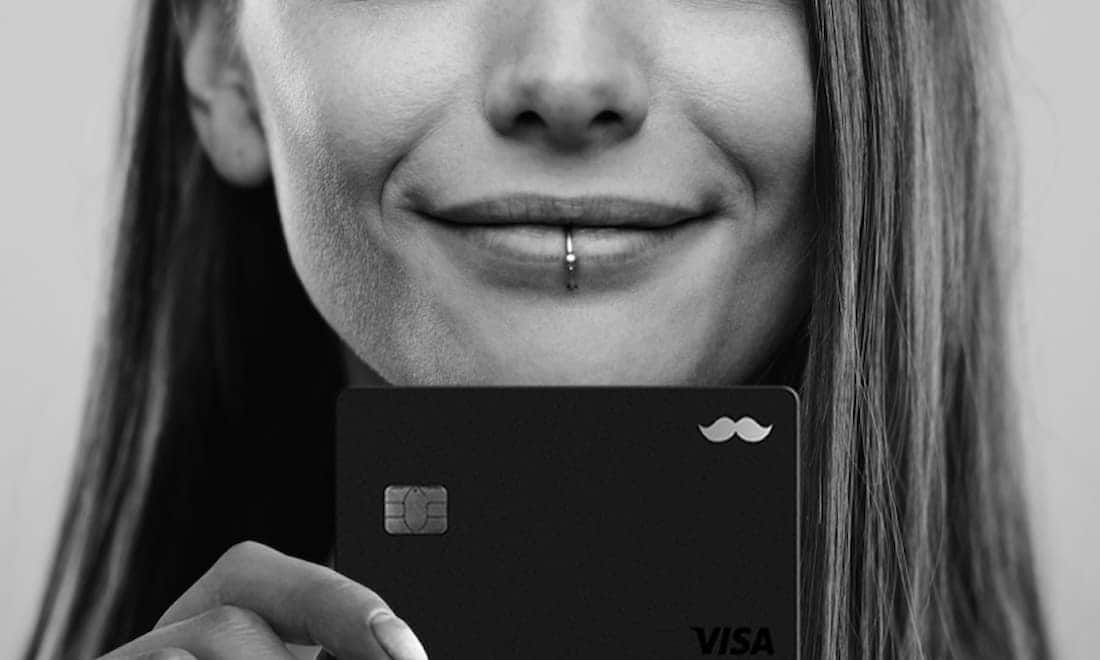 Mulher sorridente segurando o cartão RappiBank