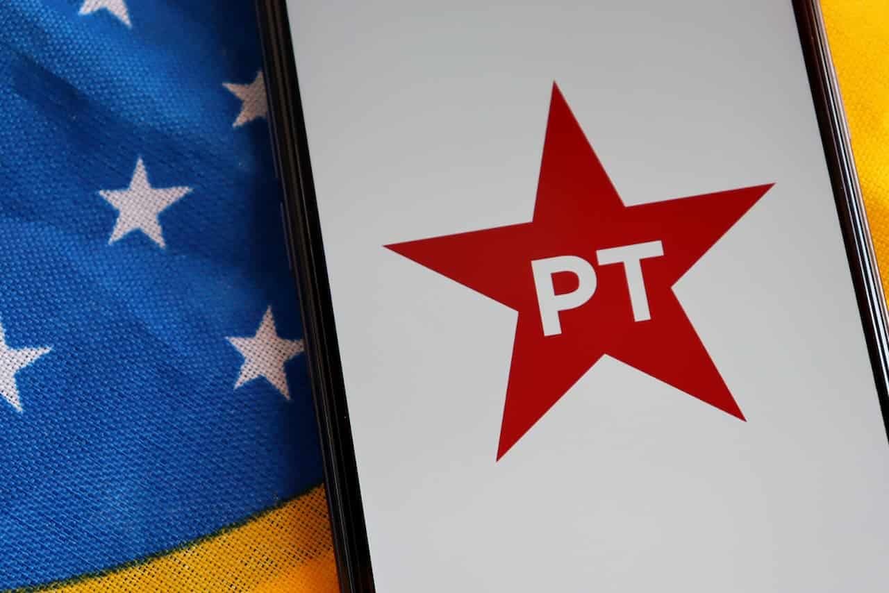 Posicionado em cima da bandeira do Brasil, celular exibe logo do PT