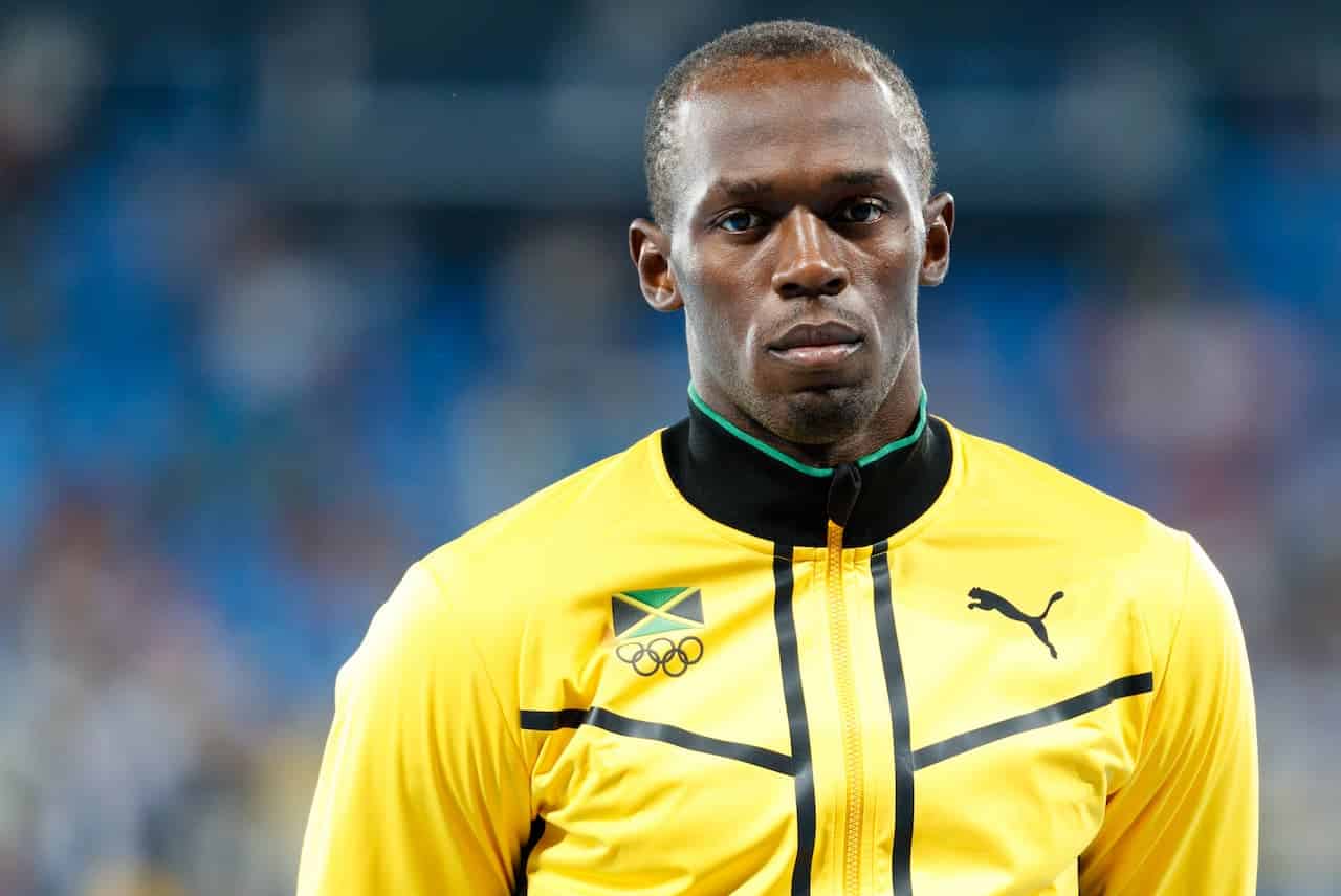 Atleta Usain Bolt com expressão séria no rosto em pódio