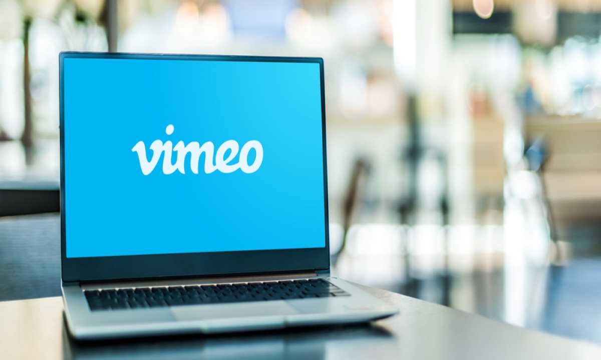 Notebook em cima de uma mesa exibindo a logo da Vimeo