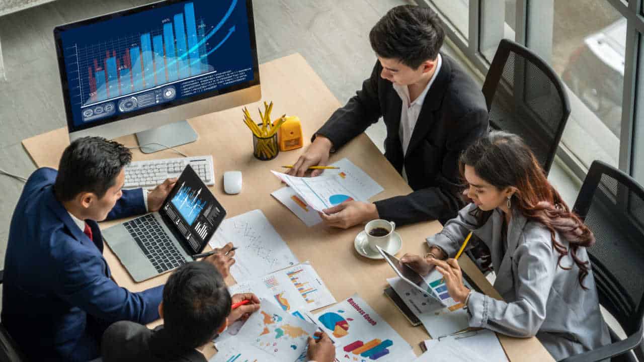 profissionais trabalhando em uma empresa, analisando dados e métricas