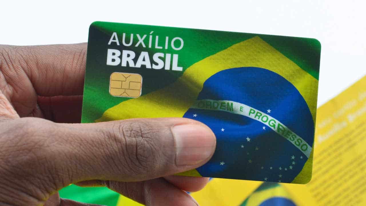 Cartão do Auxílio Brasil na mão