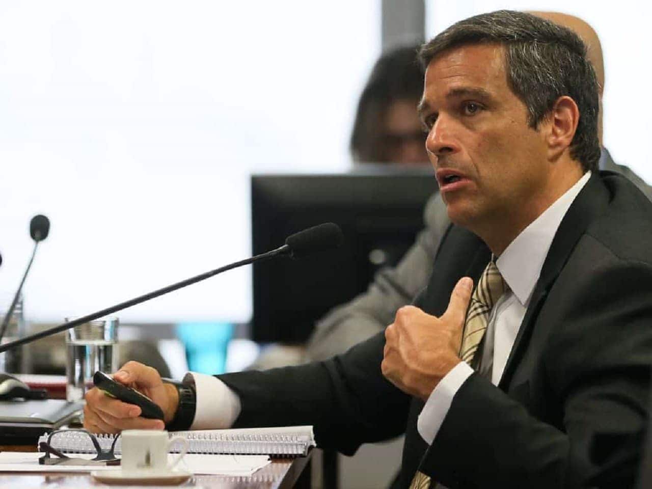 imagem do presidente do Banco Central, Roberto Campos Neto, discursando em microfone
