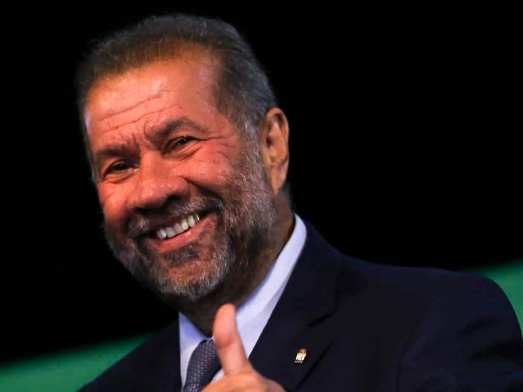 Carlos Lupi dando um joia enquanto fala do INSS