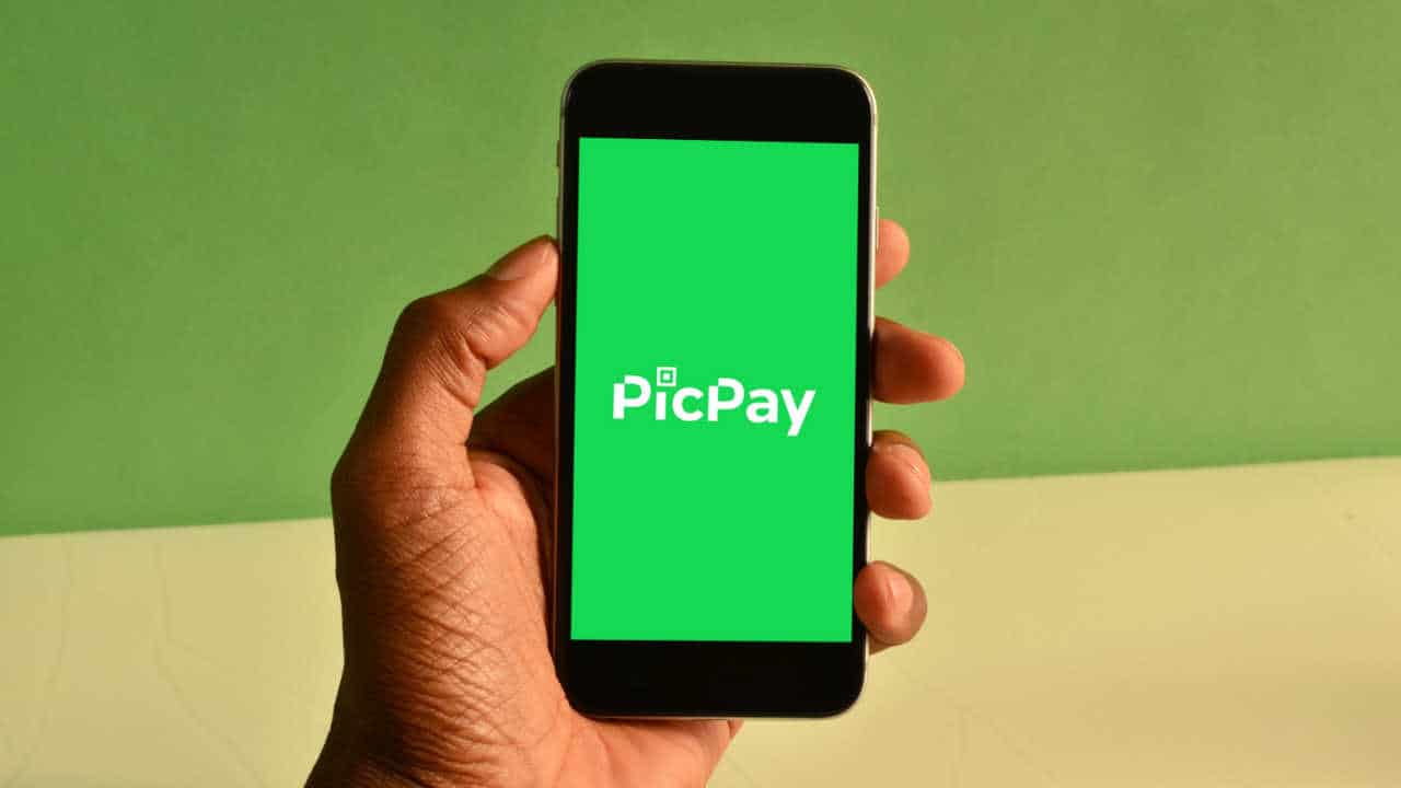 Celular na mão com app do PicPay na tela inicial