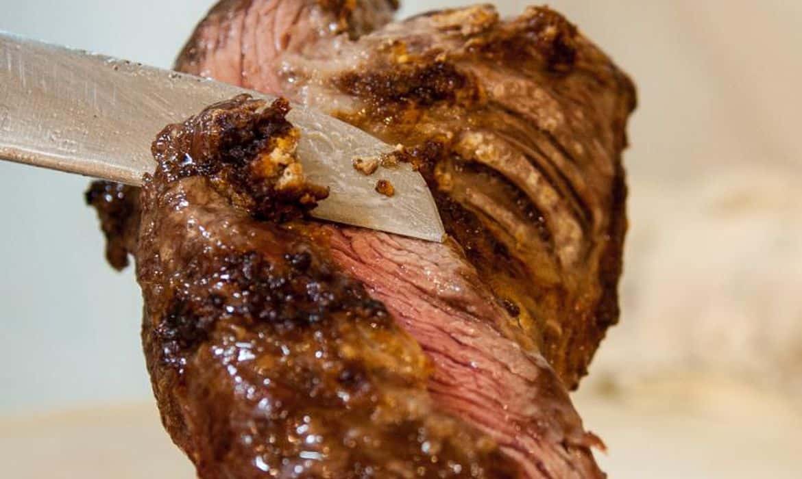 Picanha no espeto sendo cortada