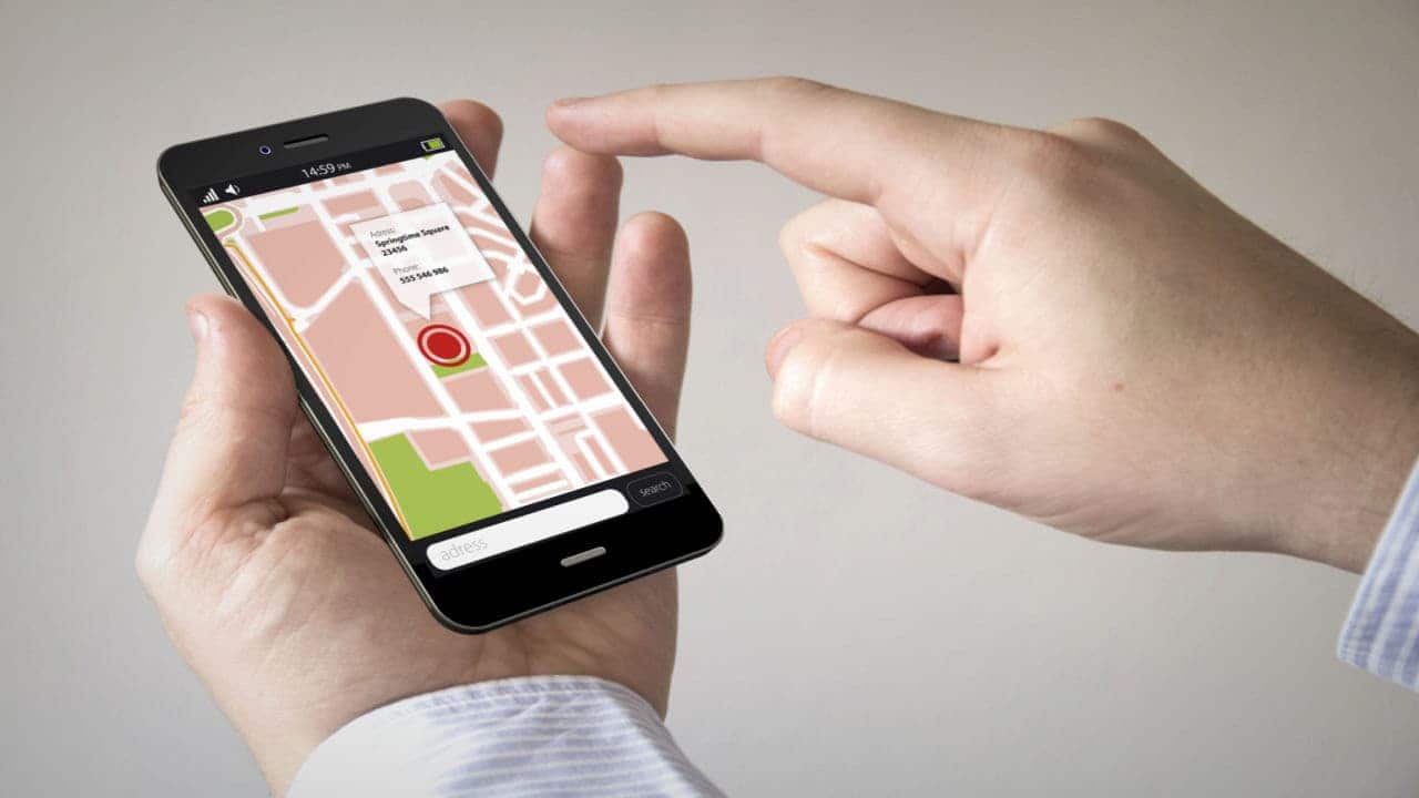 Pessoa segurando celular que exibe um mapa