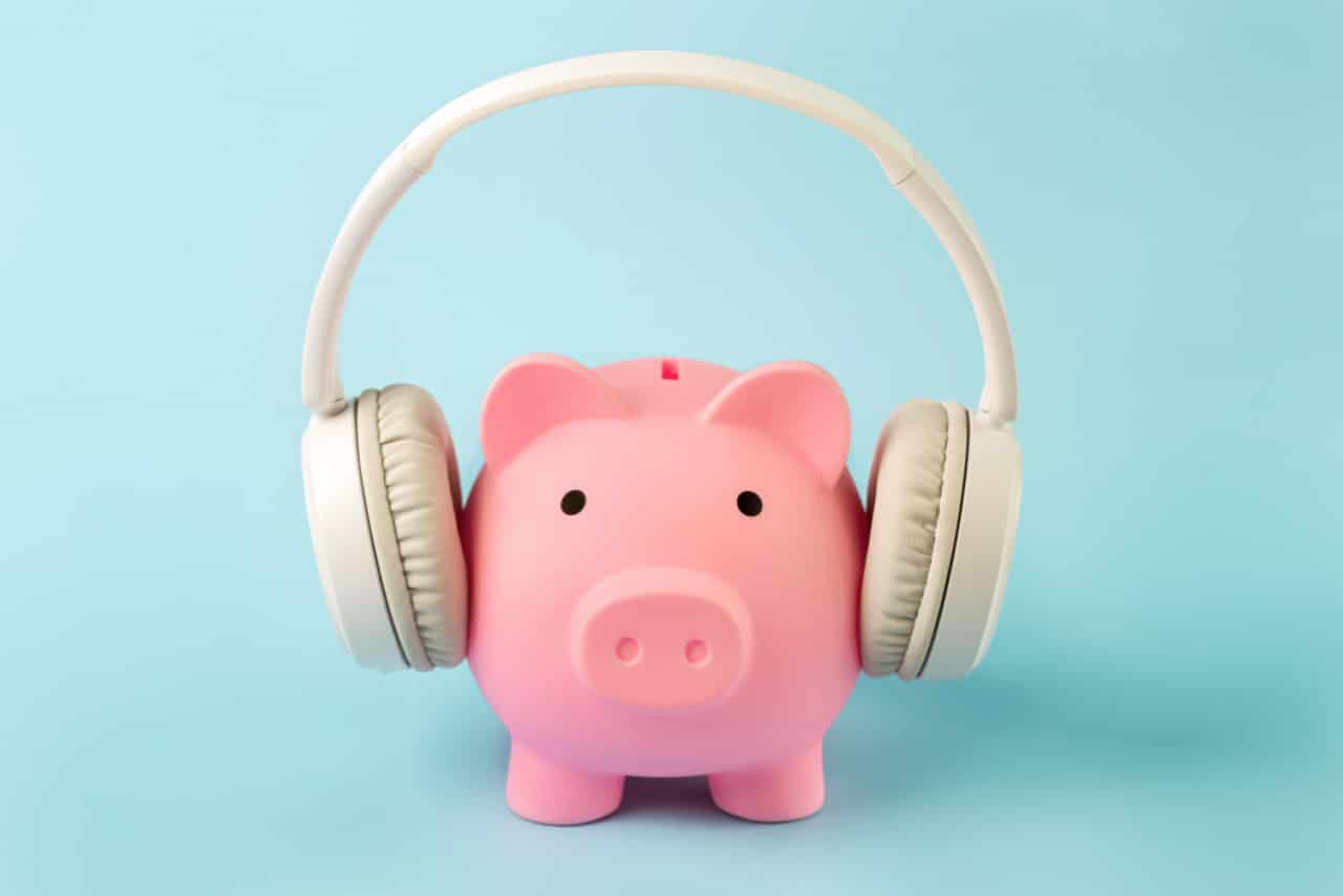 Cofre em forma de porquinho entre os fones de um headset
