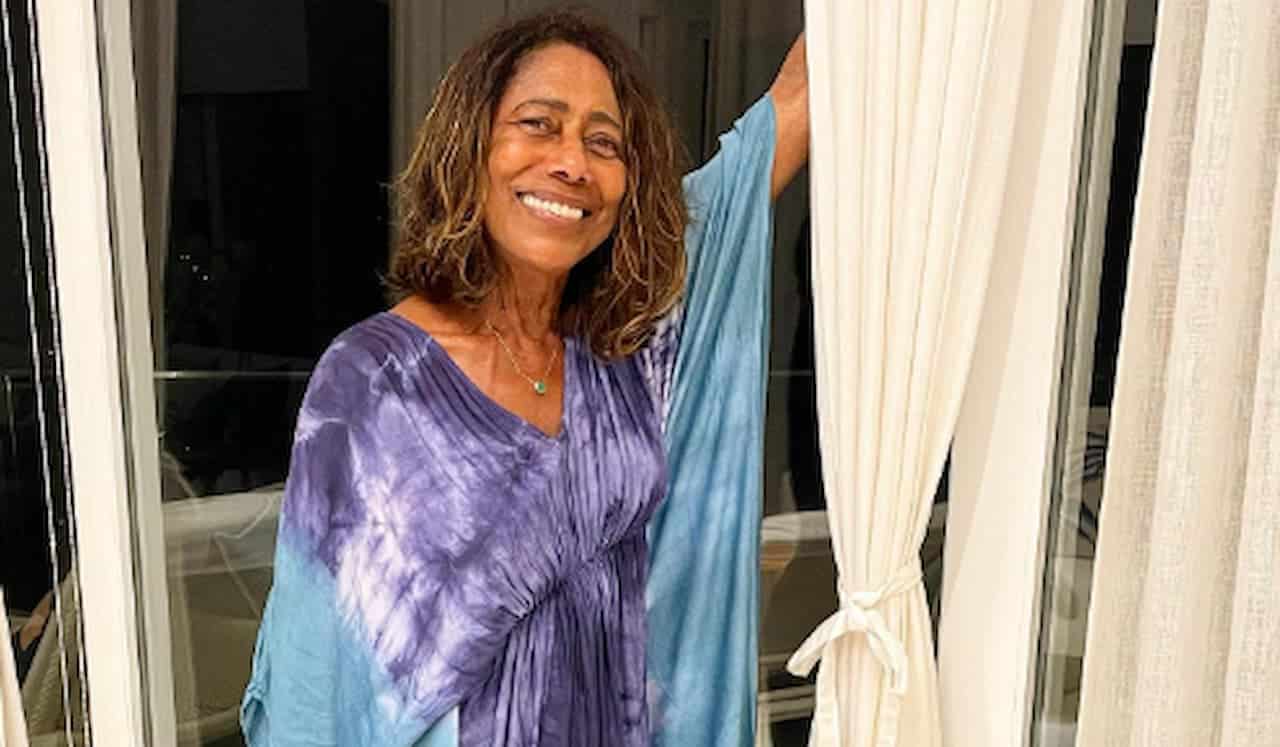 Gloria Maria vestida de azul e sorrindo