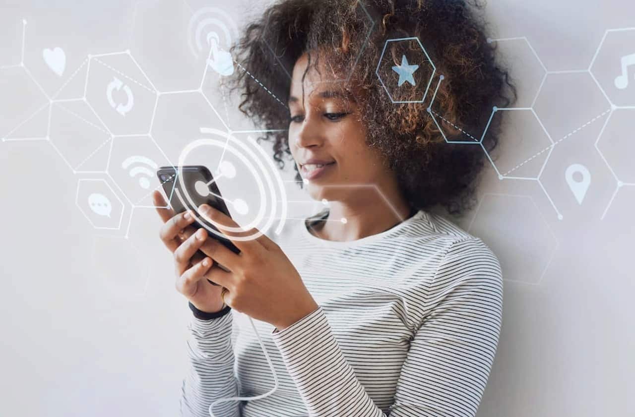 Mulher usando internet no celular enquanto sorri