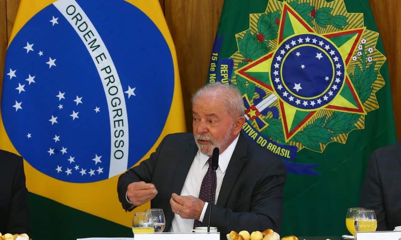 Lula sentado em uma mesa com alimentos