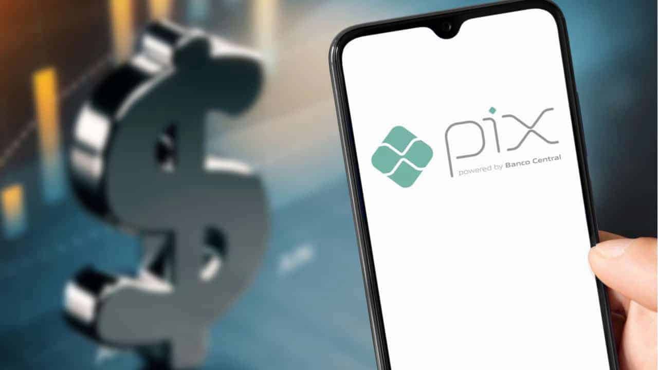 Celular que mostra logo do Pix e cifrão do dinheiro ao fundo