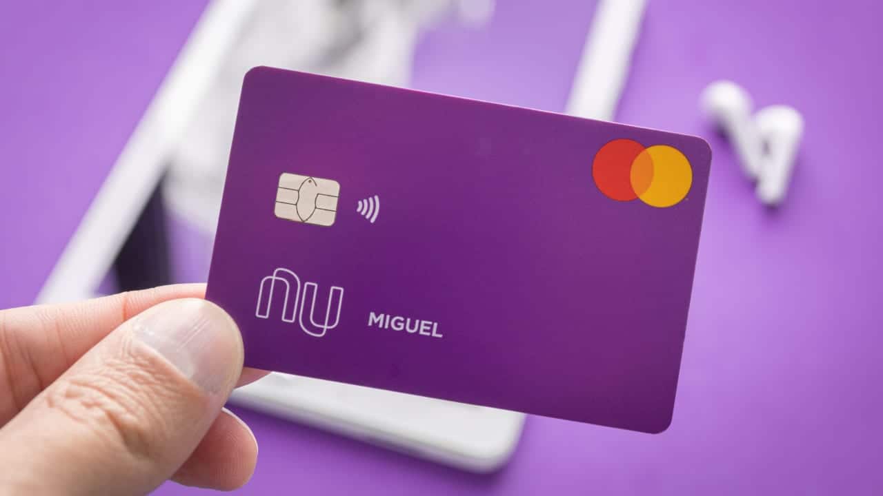 Mão segurando cartão do Nubank