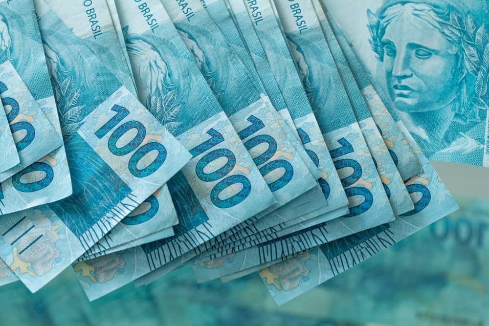 Várias notas de 100 reais espalhadas.