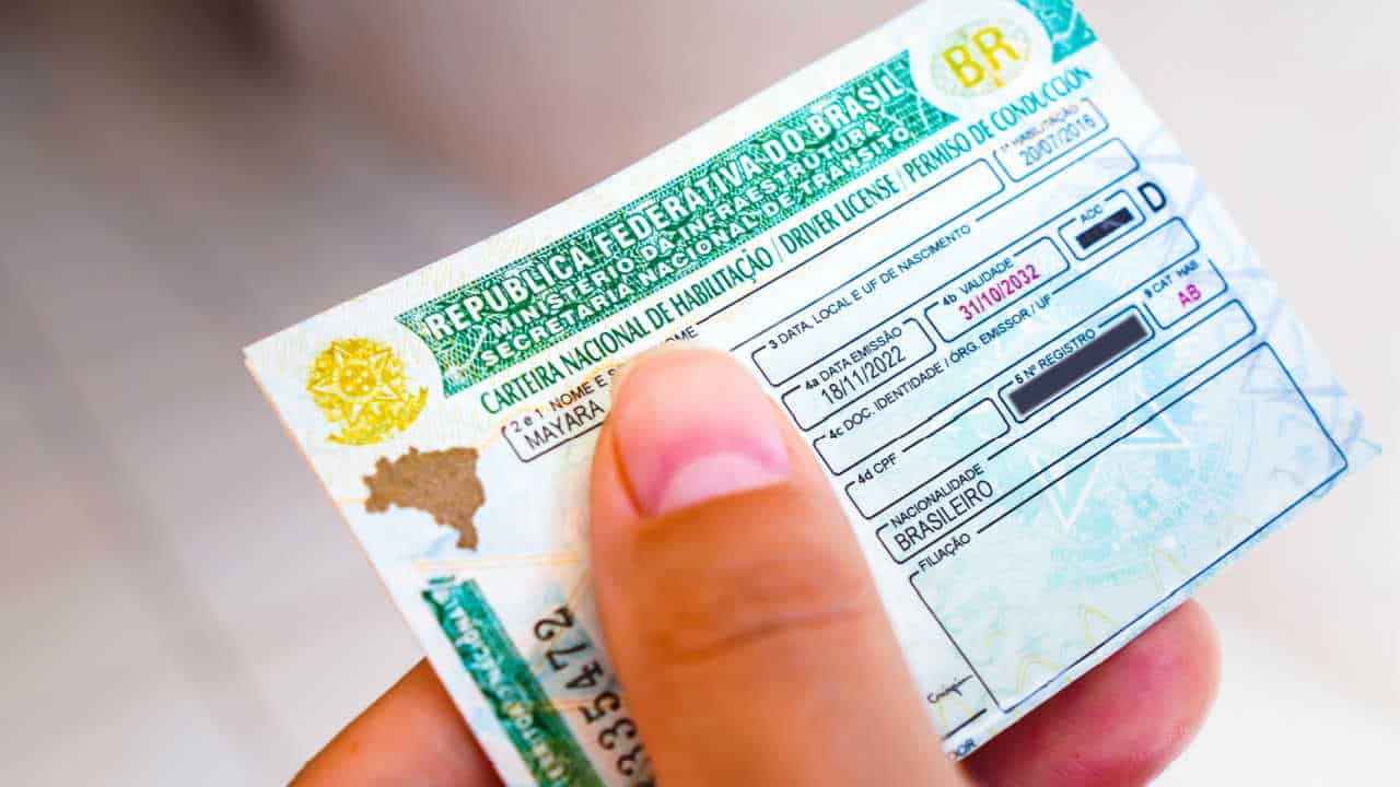Mão segurando uma CNH