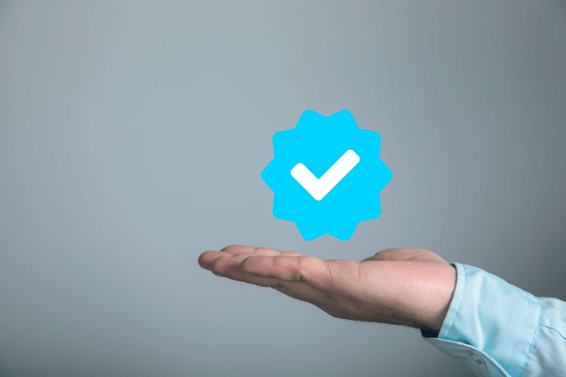 ícone do selo de verificado flutuando sob uma mão estendida