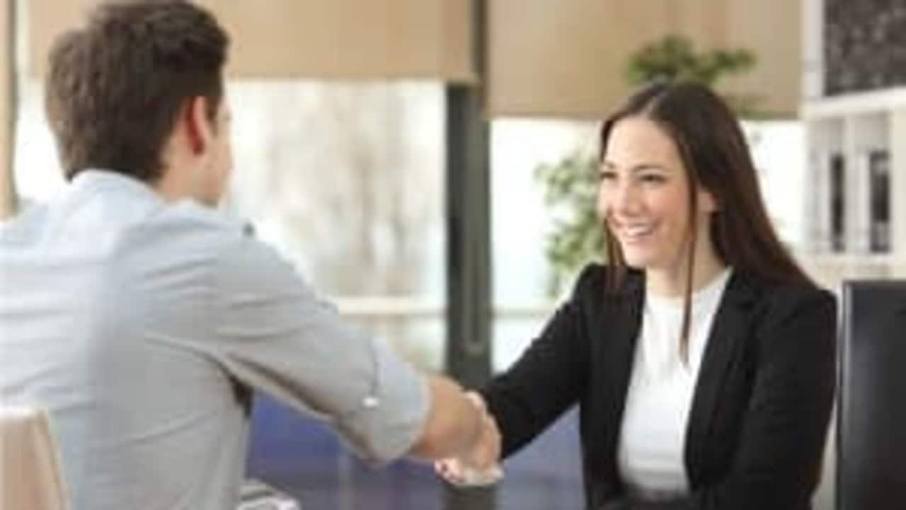 Duas pessoas se cumprimentando em uma entrevista de emprego