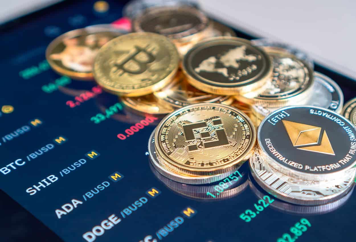 Criptomoedas espalhadas por uma tela de cotações