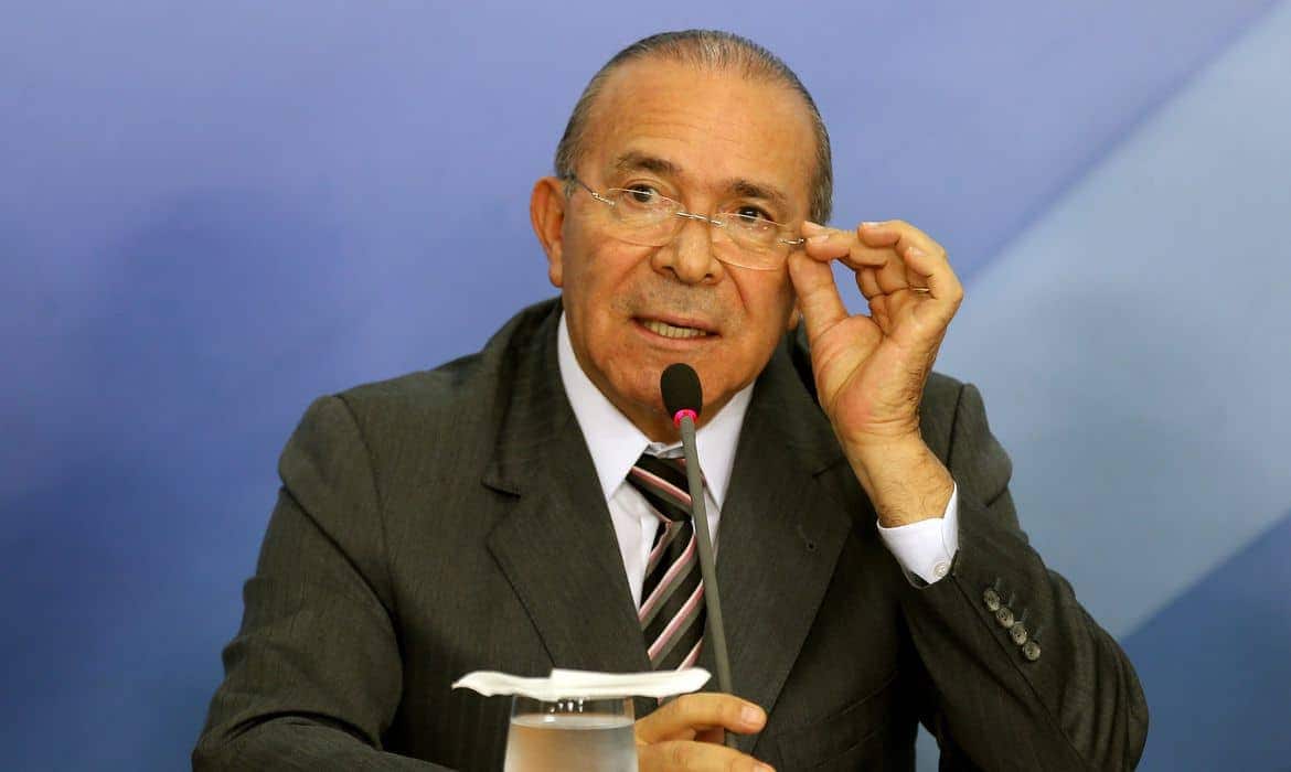 Eliseu Padilha de óculos e cabelos grisalhos, de terno falando ao microfone