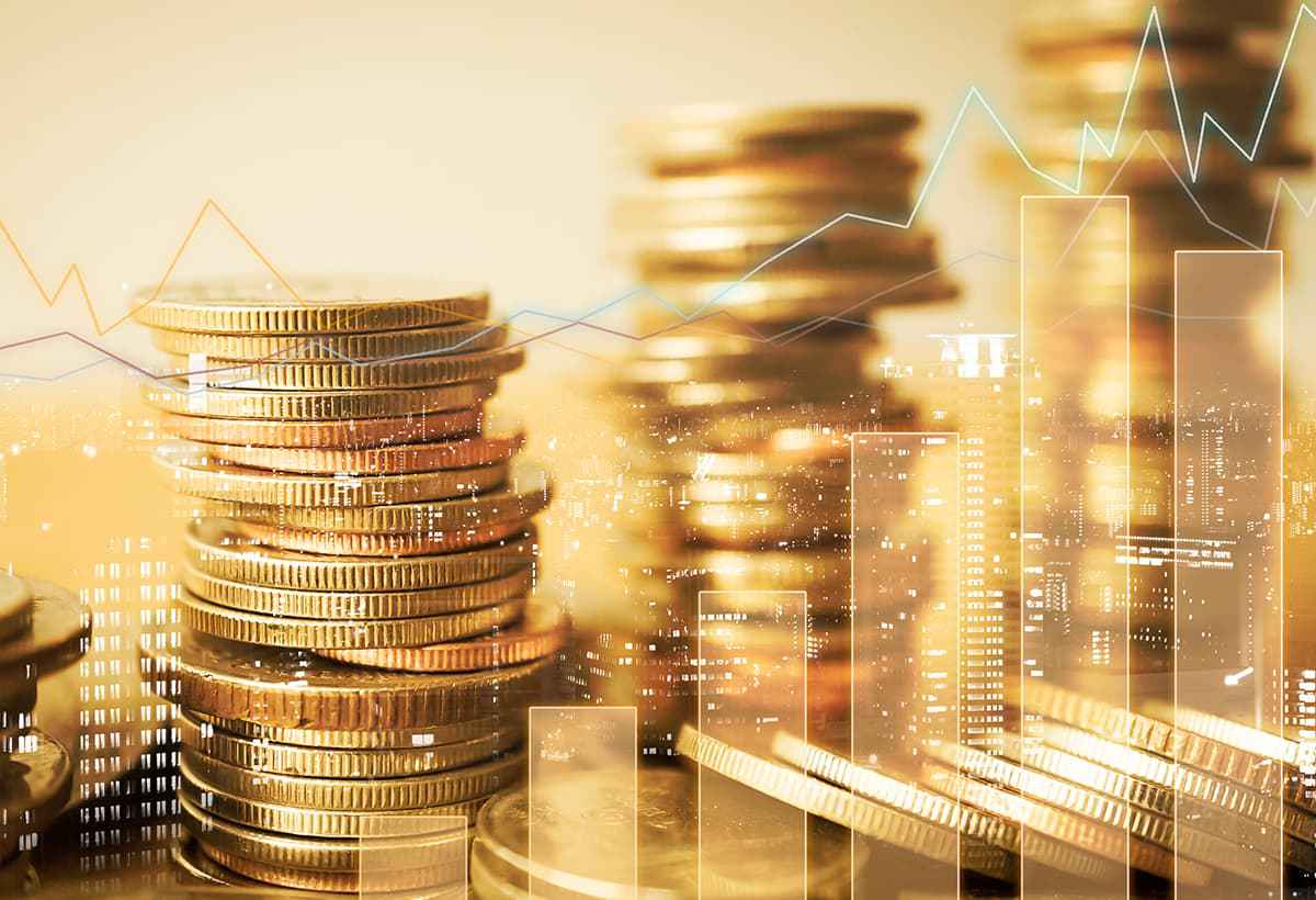 Diversas pilhas de moedas douradas com linhas de gráficos sobrepostas etanol dívida global