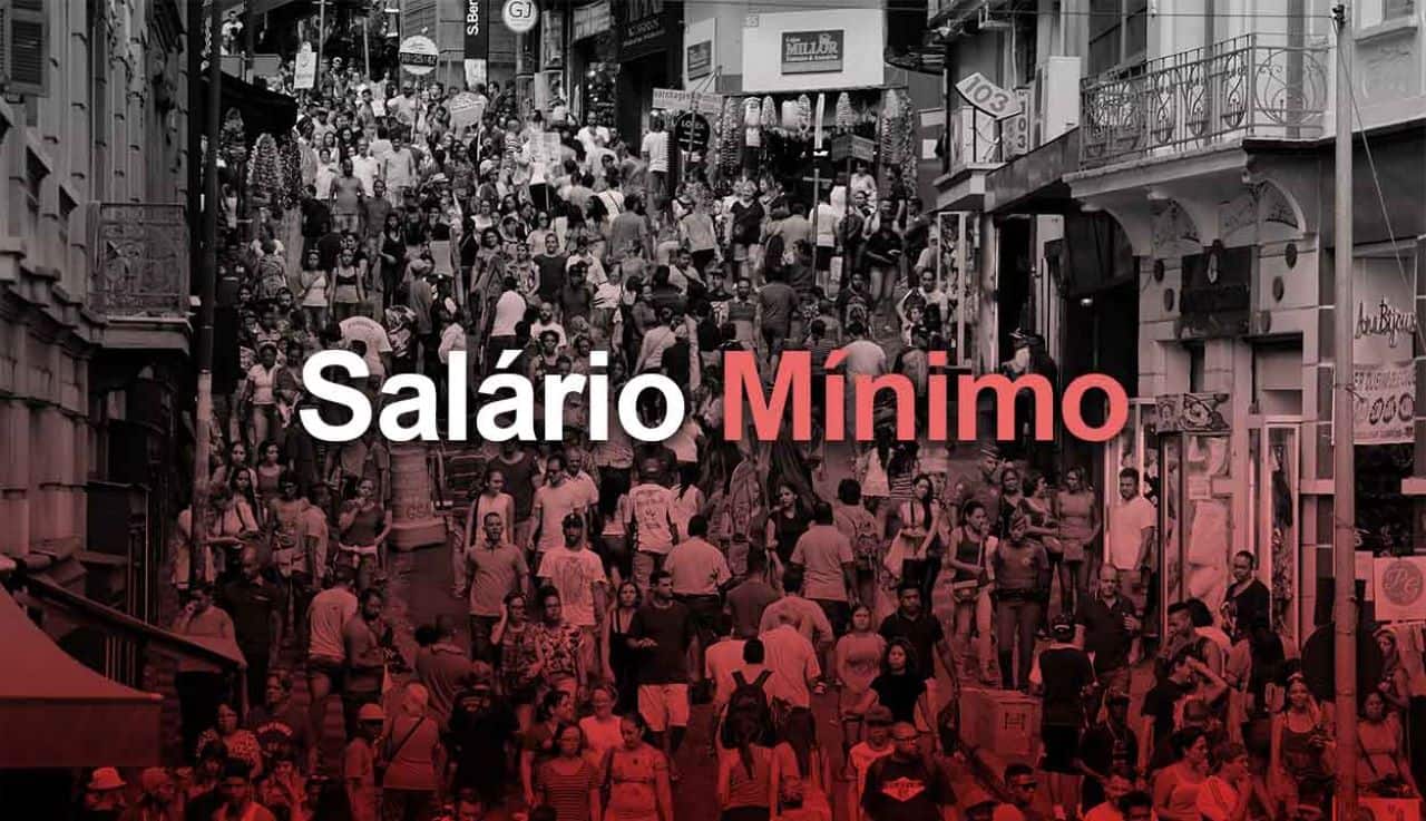 Multidão na rua com a escrita "Salário mínima" em evidência em vermelho