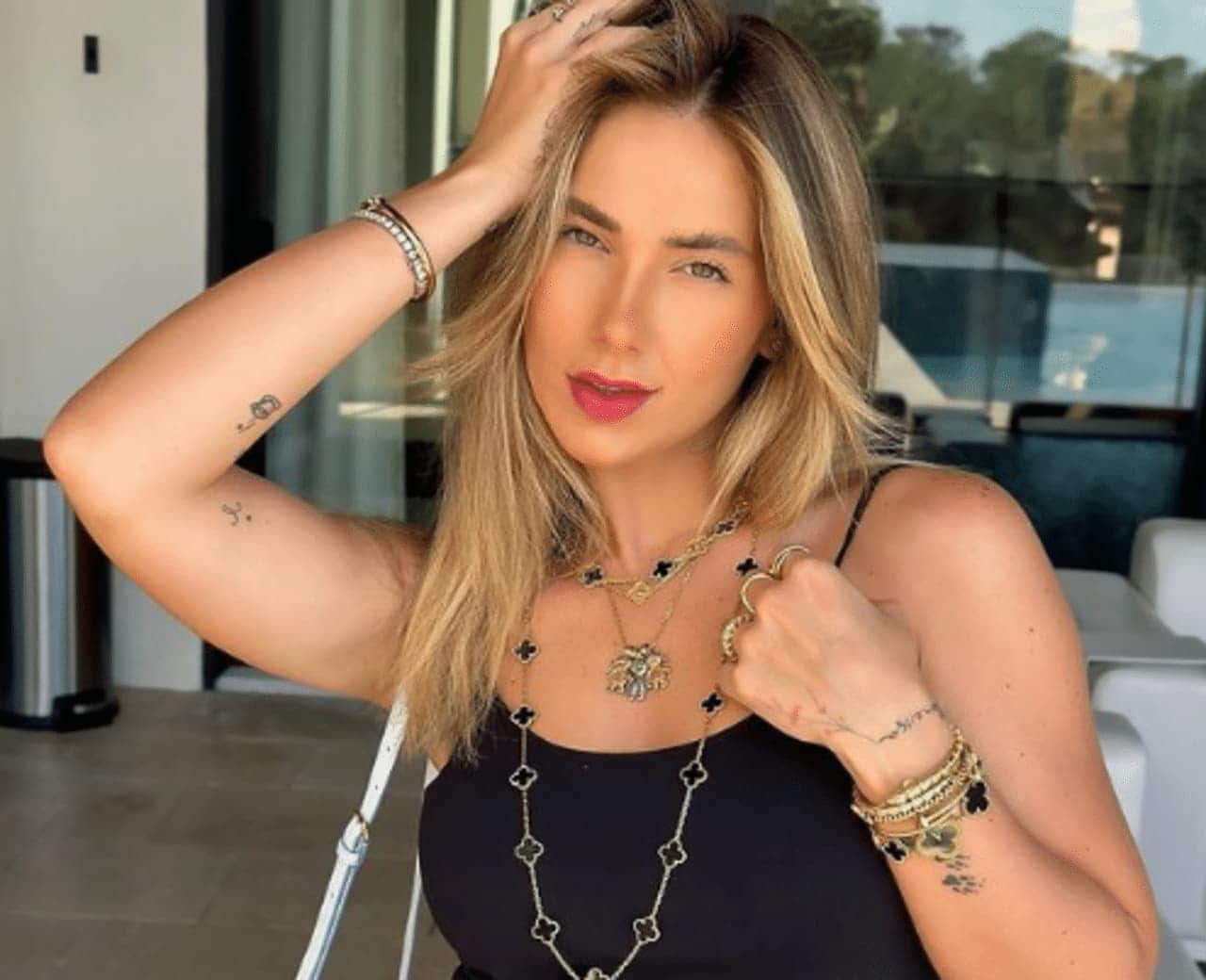 Virgínia Fonseca com uma mão na cabeça vestindo uma regata preta e acessórios