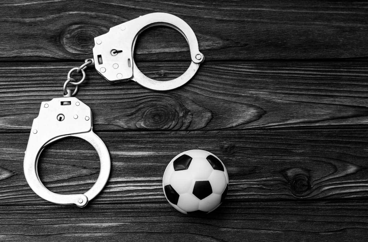 algemas e bola de futebol remetendo a crime no meio do esporte