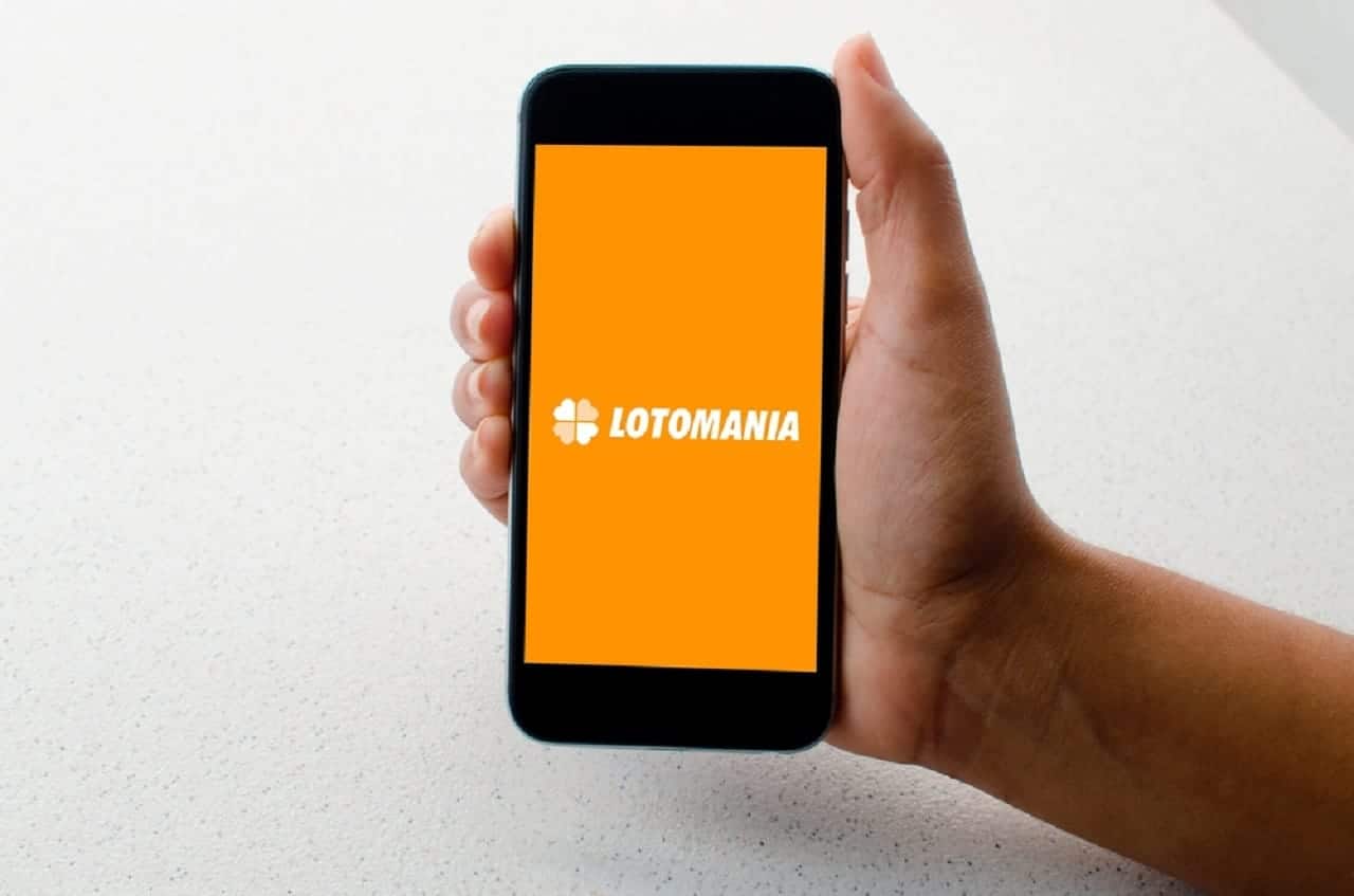 Imagem de uma mão segurando um celular com o aplicativo de aposta online "Lotofácil" aberto