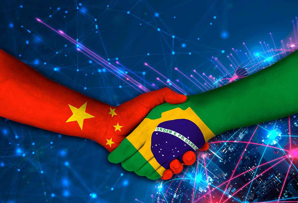 Duas mãos se cumprimentando, enquanto cada uma ilustra as bandeiras do Brasil e da China