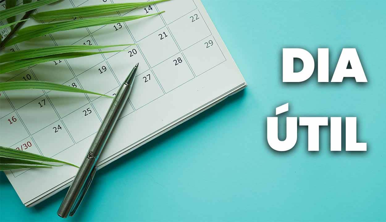 Foto de um calendário com uma caneta em cima em fundo azul