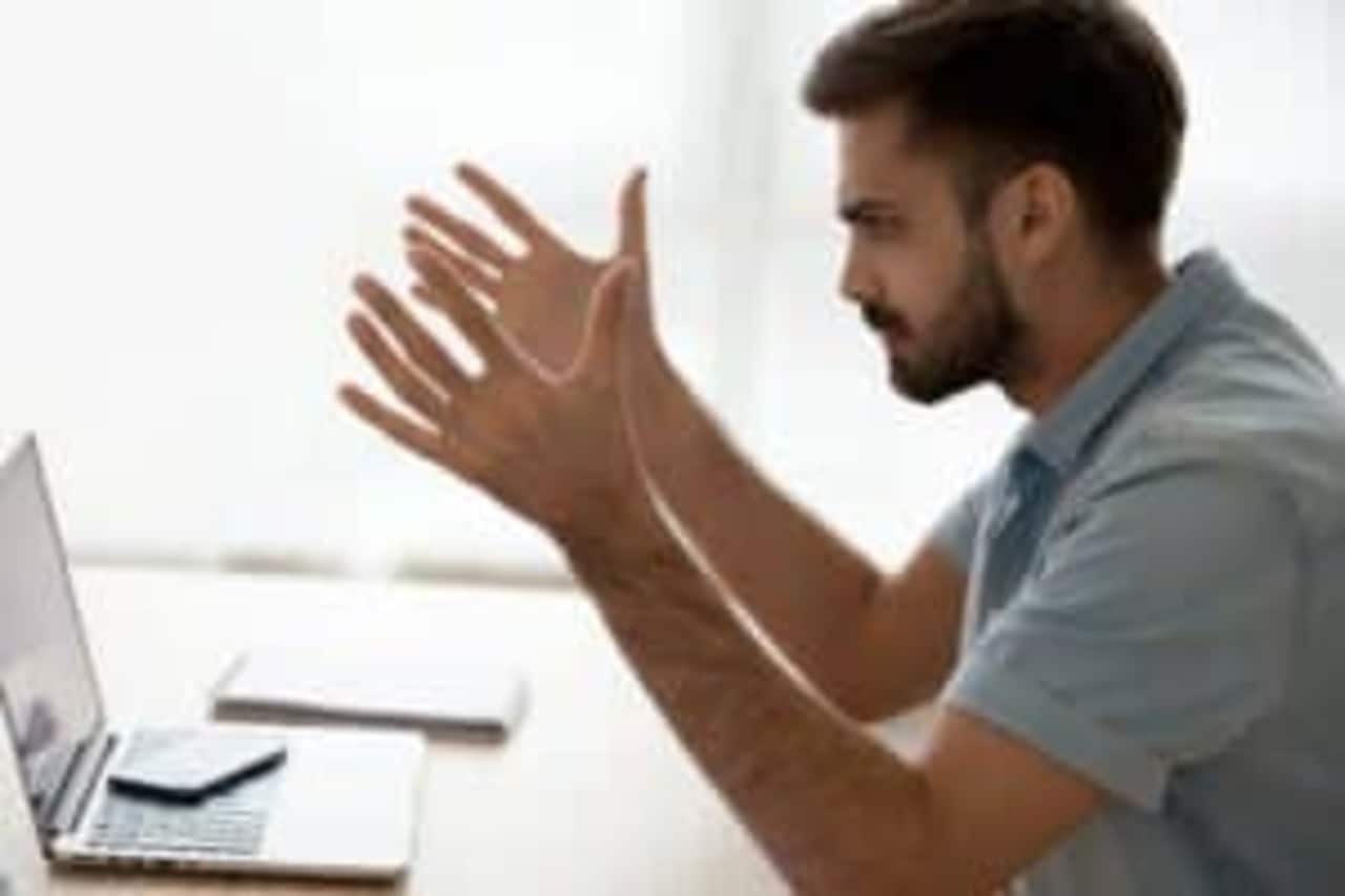 Imagem mostra um rapaz olhando indignado para a tela do computador.