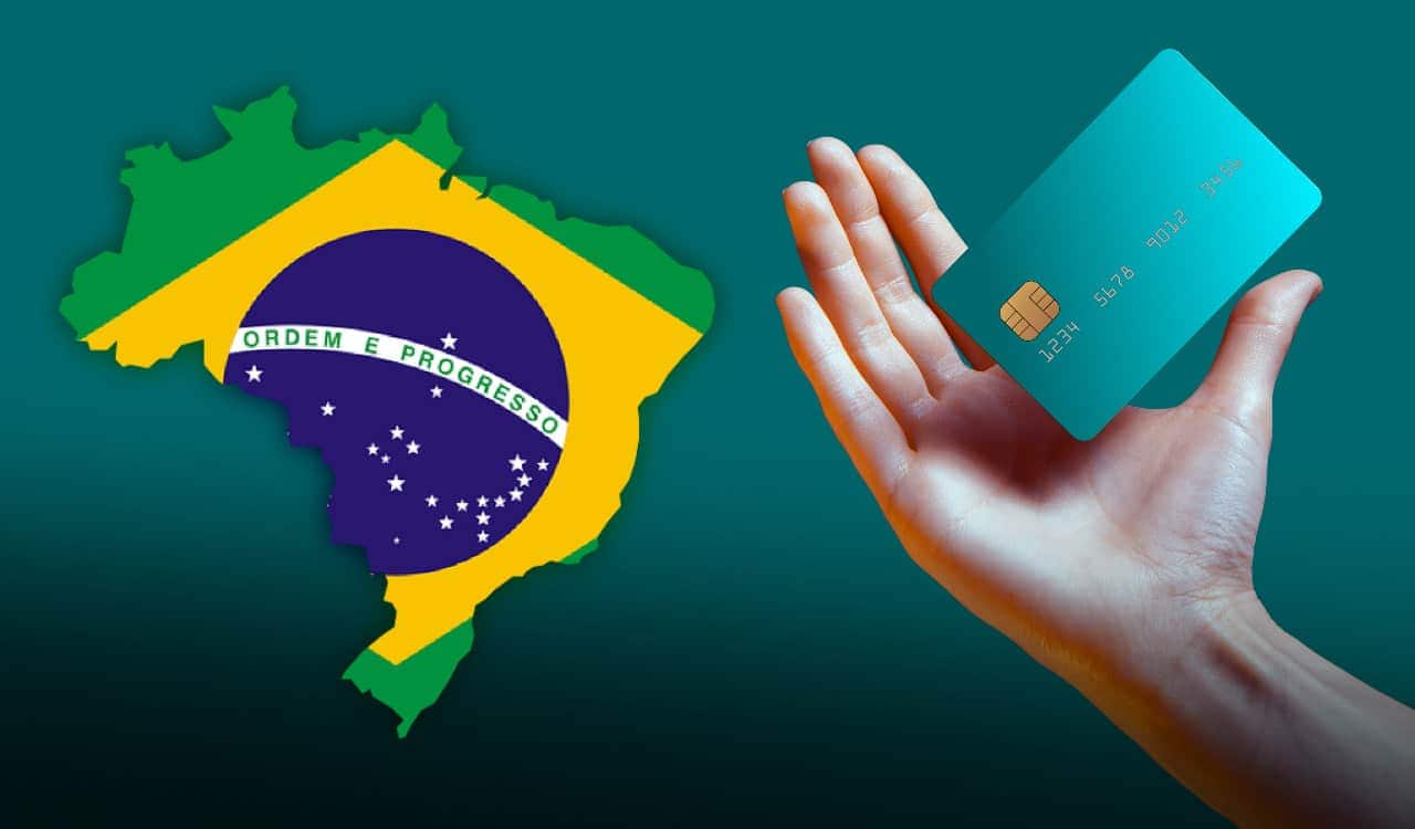 Bandeira do Brasil estampada com a bandeira nacional ao lado de uma mão segurando um cartão de crédito