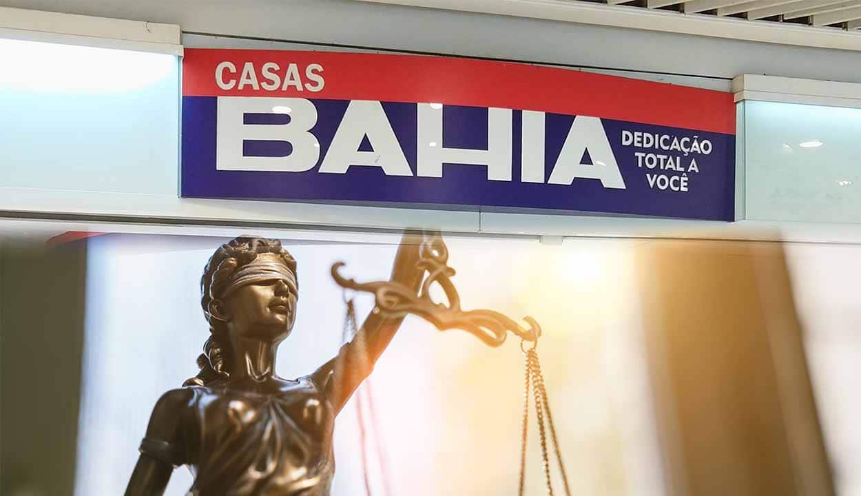 Logotipo das Casas Bahia em uma fachada da loja e, embaixo, uma estátua da Justiça