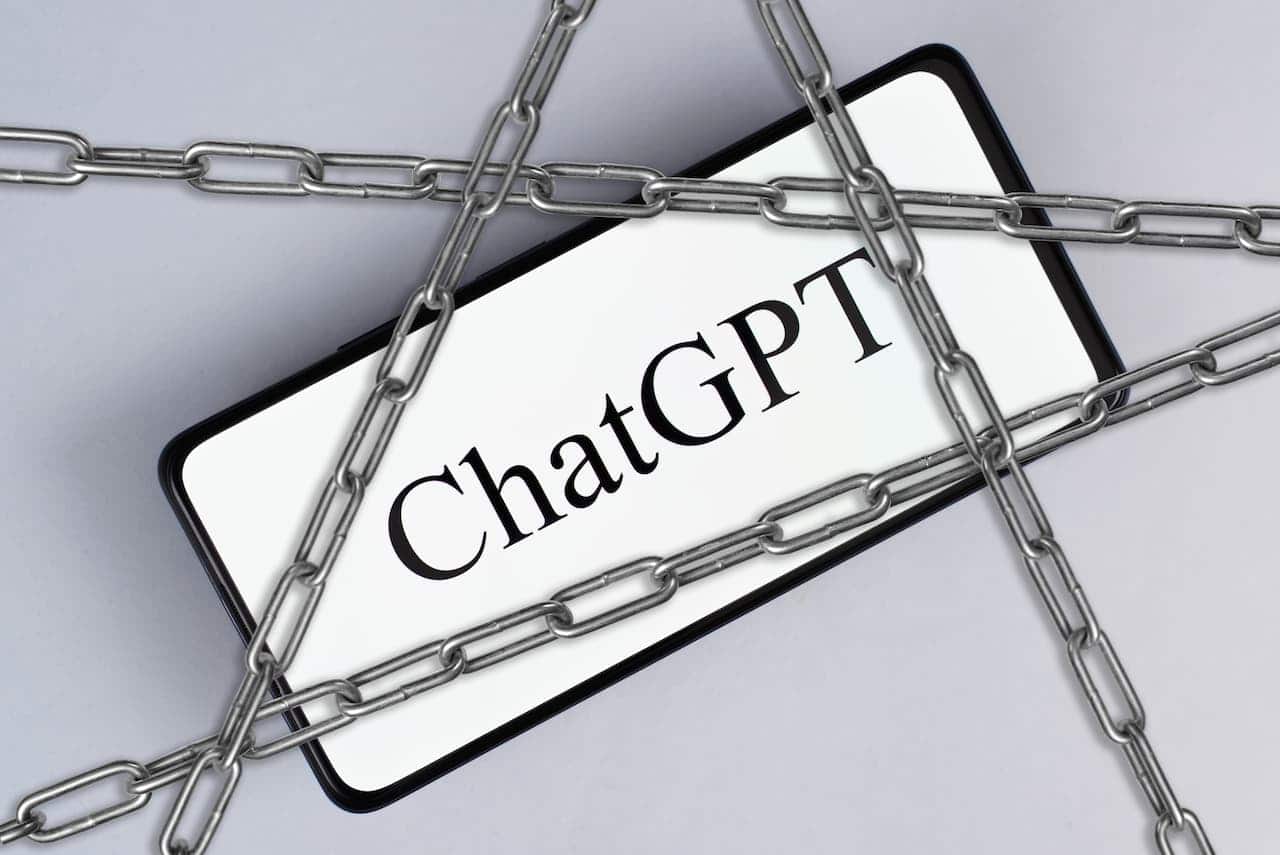 Celular com ChatGPT, correntes simbolizando proibição